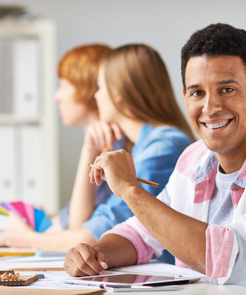 Smart guy looking at camera while sitting at workplace